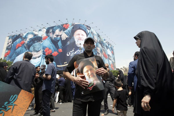 Iraníes, con retratos de Ebrahim Raisi, participan en una ceremonia fúnebre del difunto presidente