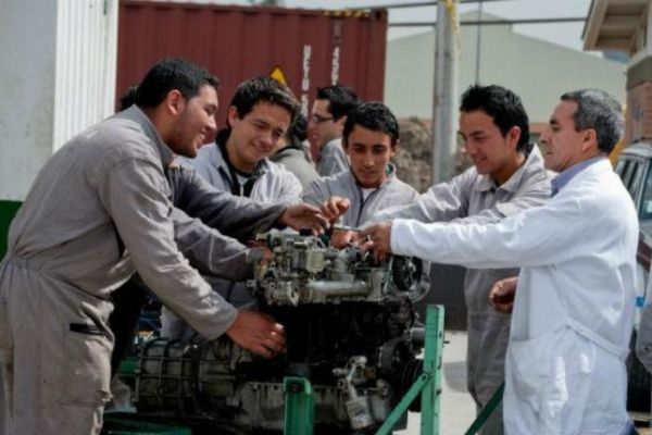 Empleados de una empresa realizando un mantenimiento a una maquinaria industrial. Foto Alcaldía de Bogotá