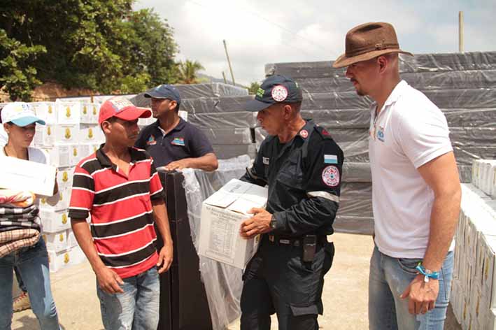 Jaime Avendaño, director de Gestión de Riesgos realizando la entrega de las ayudas humanitarias en la cancha de Guachaca.