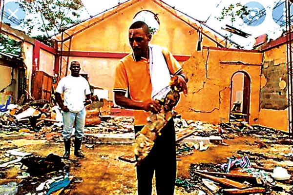 En la fotografía de instantes posteriores a la incursión armada en la iglesia de Bojayá, aparecer el padre Antún Ramos Cuesta con el Cristo Mutilado y Mártir de Bojayá, que años después fue bendecido por el papa Francisco en su visita a Villavicencio en septiembre de 2017. Foto cedida por el padre Antún Ramos Cuesta
